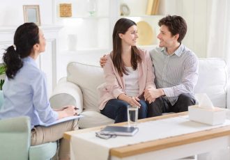 happy-couple-at-successful-therapy-session-with-fa-W9KXY7U-scaled.jpg
